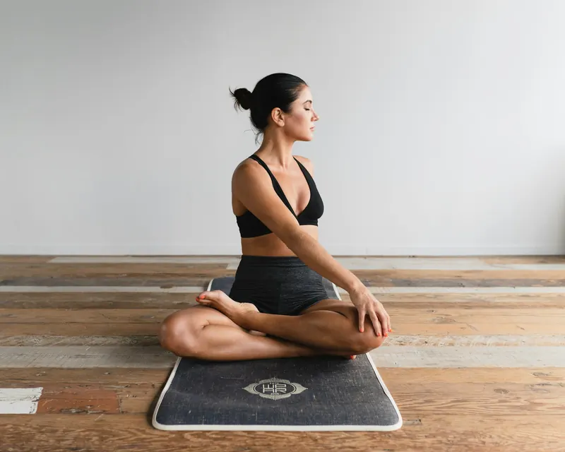 Woman sitting tall and upright on a mat, practicing posture and breathing